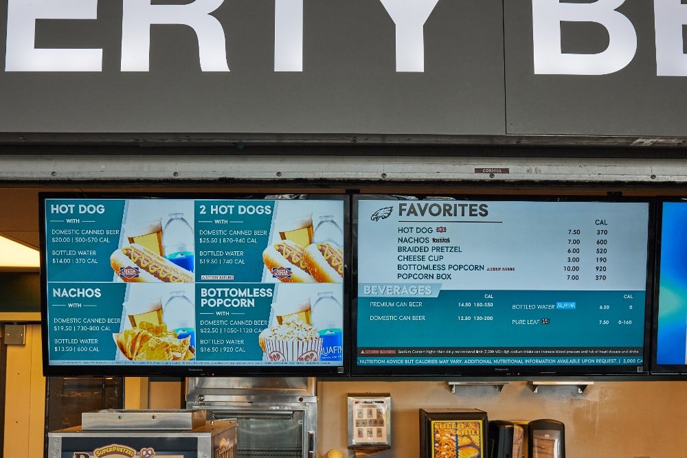 Concession stand menu featuring hot dogs, nachos, and beverages at a USA sports stadium